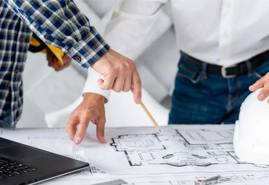 Profesionales de Lewis dibujando planos arquitectónicos con pasión y precisión